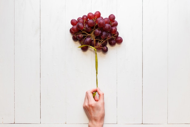 Bunch of grapes tied with a ribbon in a woman's hand