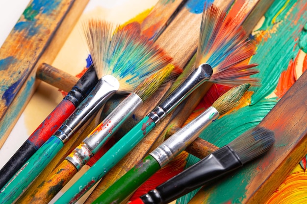 A bunch of paint brushes are lined up on a table.