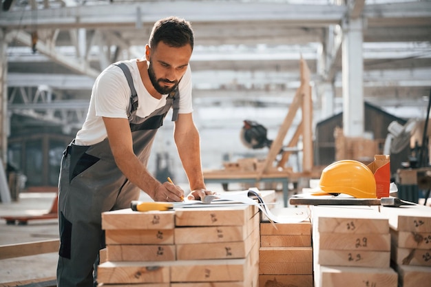 Bunch of paper documents and plans Industrial worker in wooden warehouse