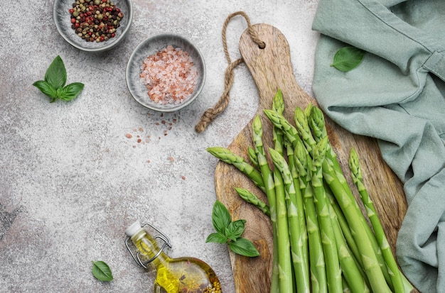 Bunch of raw asparagus stems with different spices