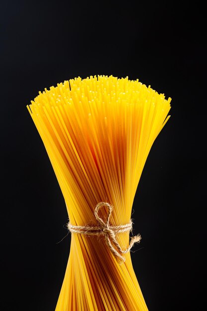 A bunch of raw Italian pasta shot in backlight against a dark background