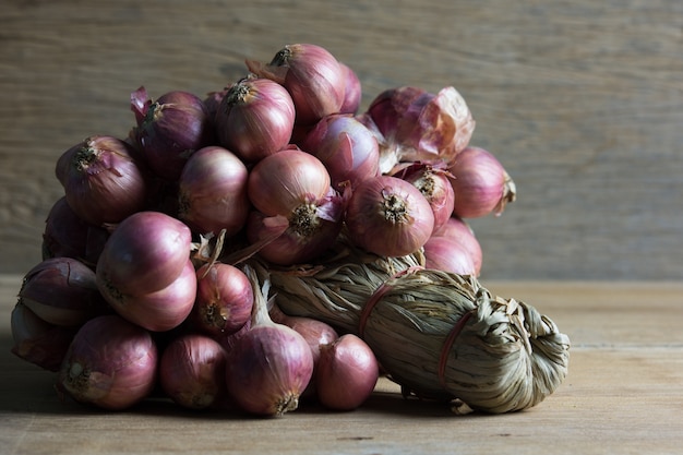 Bunch of red onions on wooden tabel with copy space, Shadow concept, Vintage style.