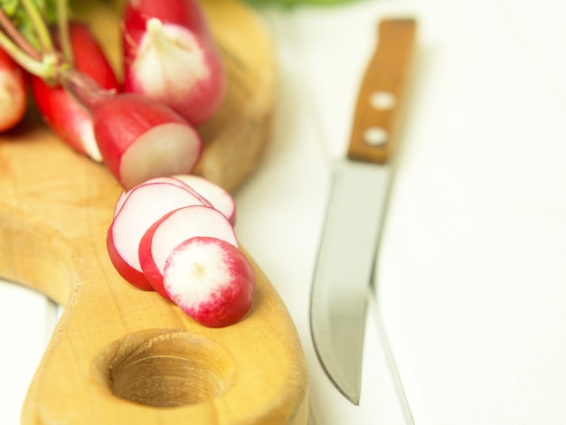 A bunch of red radishes on a wooden background