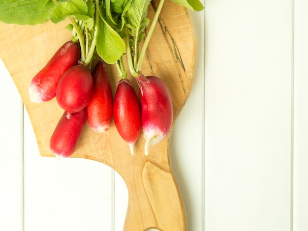 A bunch of red radishes on a wooden background