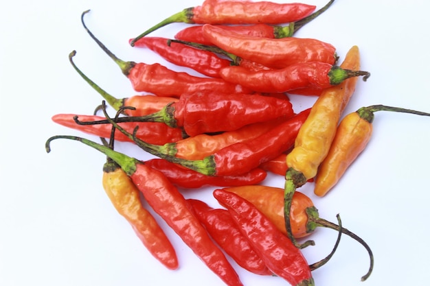 A bunch of red and yellow chili peppers are on a white background.