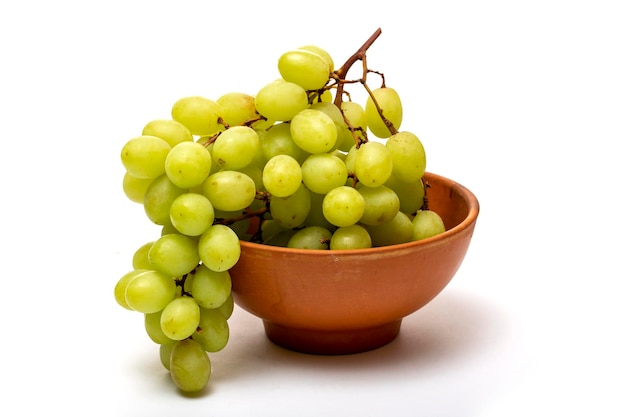 A bunch of ripe grapes in a plate on a white background