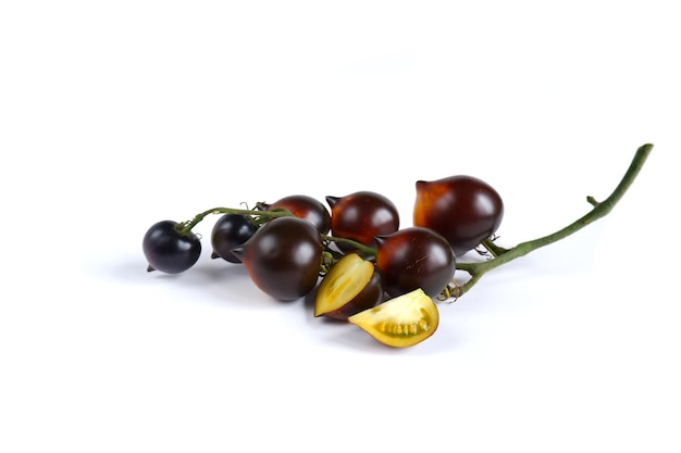 A bunch of ripe tomatoes with purple and orange skin and yellow flesh on a white background.