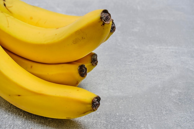 Bunch ripe yellow bananas gray concrete background