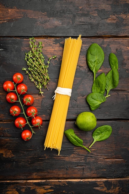 Bunch of spaghetti, raw pasta set, on old dark  wooden table background, top view flat lay