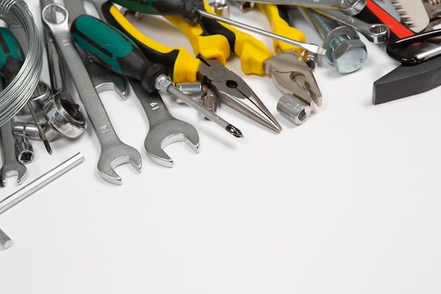 A bunch of tools are lined up together on a white surface.