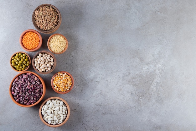 Bunch of uncooked lentils, beans and rice on stone background. 