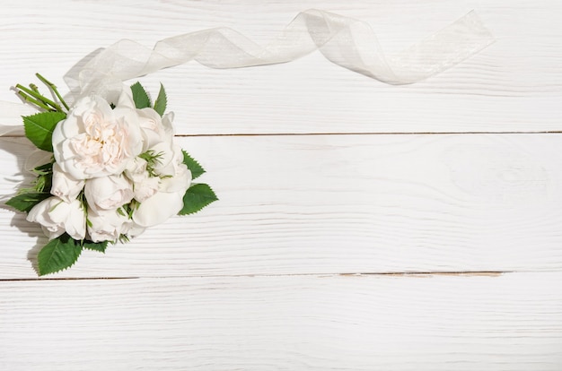 Bunch of white roses on white table. top view