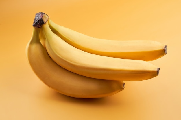 Bunch of whole bananas isolated on yellow background with copy space