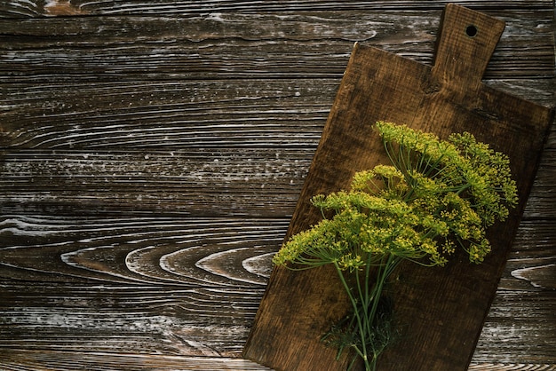 Bunches of fresh green dill greens on a brown wooden board 2