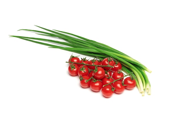 Bunches of fresh red cherry tomatoes and young green onion isolated on white background Ripe tomatoes on green stems Bunch of fresh onion Fresh organic vitamin vegetables