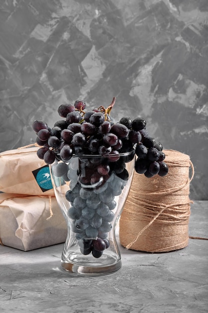 Bunches of fresh ripe red grapes on a concrete textural surface Branch of pink grapes Red wine grapes dark grapes Still life of food Nature Autumn harvest Vegetarian nutrition Winery