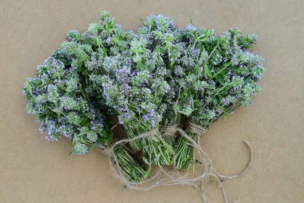 Bunches of thyme on wooden table Thyme bouquets on eco friendly craft paper background