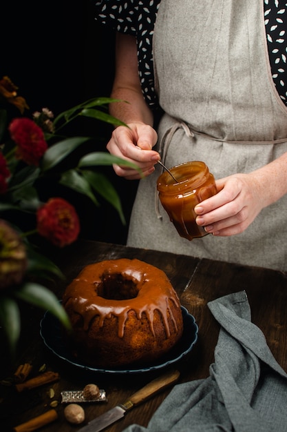 Bund cake with spices, cinnamon, star anise, nutmeg and caramel sauce glaze on dark wooden table