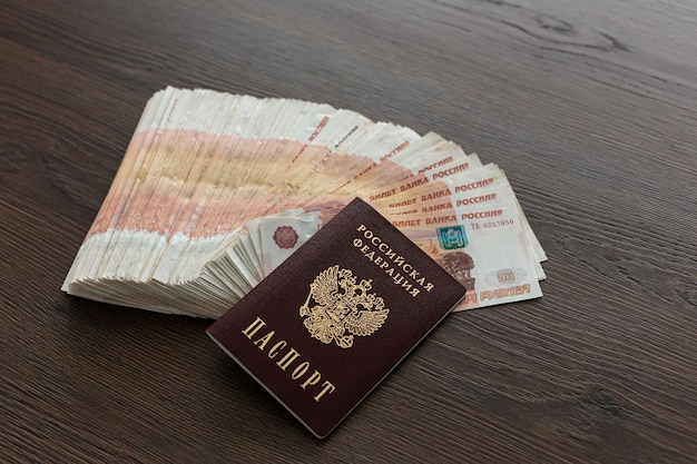 A bundle of five thousand Russian rubles is spread out on the table There are passports