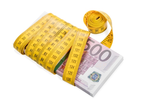 bundle of money in denomination of five hundred euros rewound with a measuring tape isolated on white background