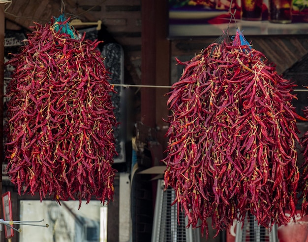 Bundles of red peppers dry in the sun