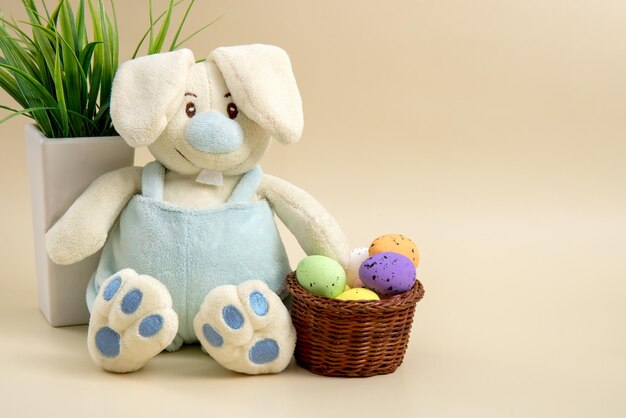 Bunny with a basket of Easter eggs on a light background with copy space