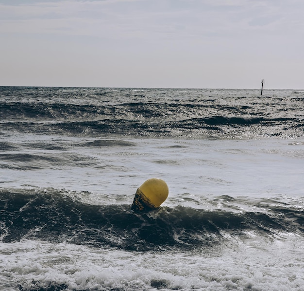 Buoy in the sea waves with foam Empty beach Summer vacations travel Stormy ocean