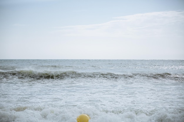 Buoy in the sea waves with foam Empty beach Summer vacations travel Stormy ocean