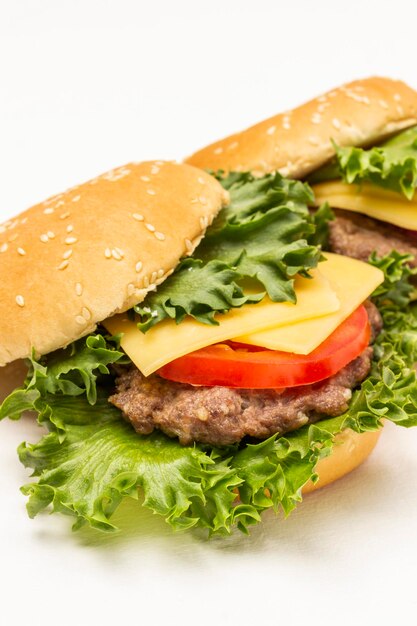 Burger bun on lettuce leaf with cheese and tomatoes