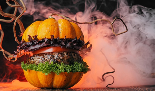 Burger Halloween halloween concept of a burger with big beef patties with pumpkin head rolls for the holiday halloween