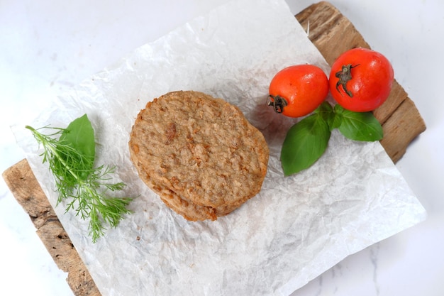 burger meat patties with vegetables on white background.