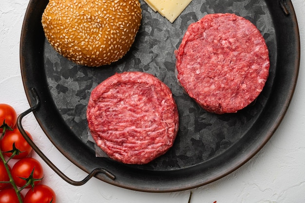 Burger patty on white stone table background top view flat lay