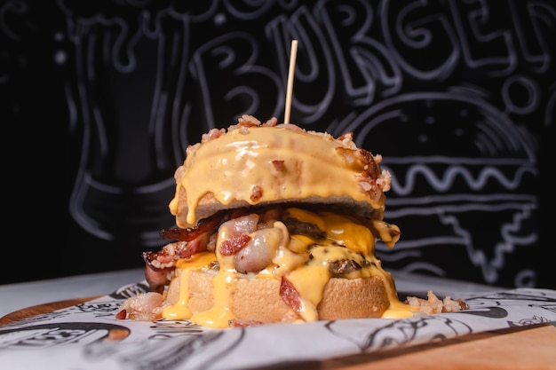 Burger topped with melted cheese on a wooden board