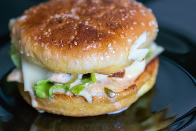 Burger with appetizing crust on a dark background