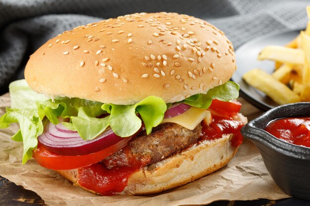 Burger with cutlet tomato cheese and greens Fresh tasty burger isolated on black background