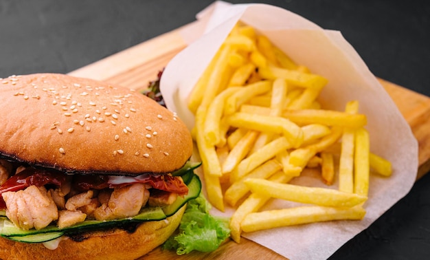 Burger with fries on wooden rustic Board