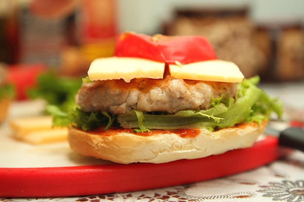 Burger with juicy cutlet cheese and fresh vegetables on the board Cooking burger in home kitchen Closeup