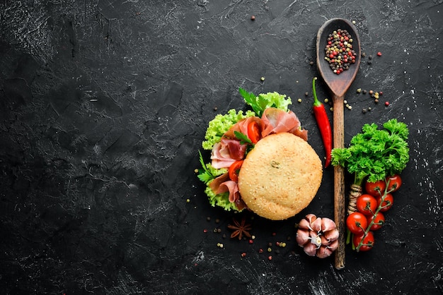 Burger with Prosciutto on old wooden background Breakfast Top view Free space for your text