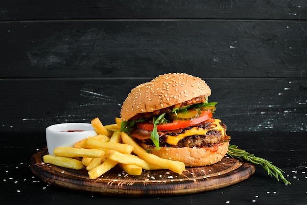 Burger with veal cheese and vegetables Fast food On a wooden background Top view Free space for your text