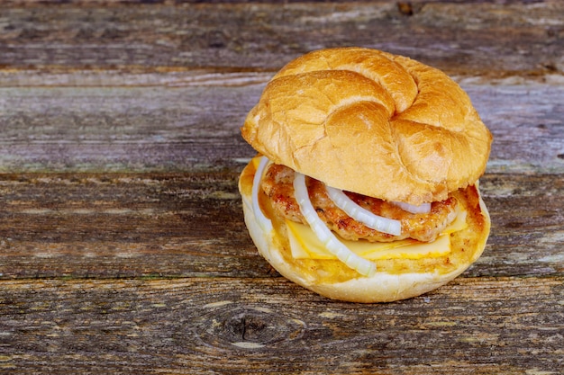 Burger on wooden background. Vintage home made burger. Fast food meal. American food.