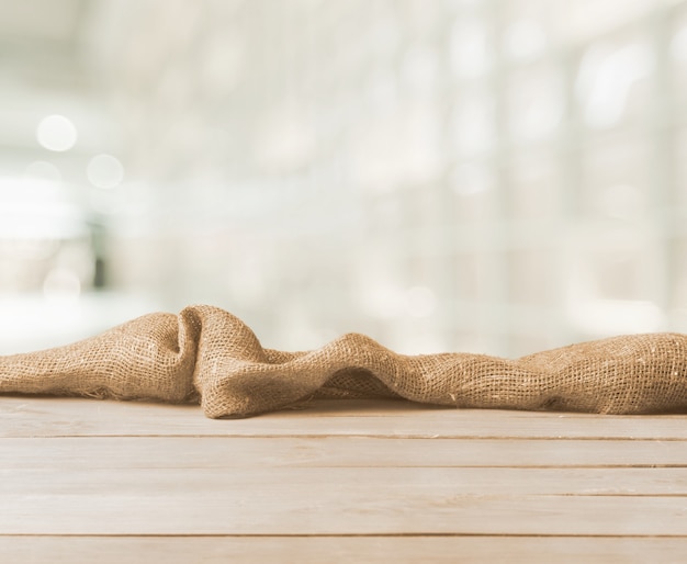 Burlap texture on wooden table on blurred background