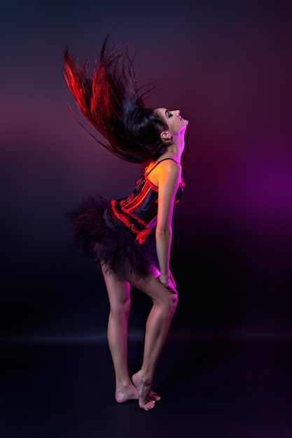 Burlesque performer in black and red corset, studio shot