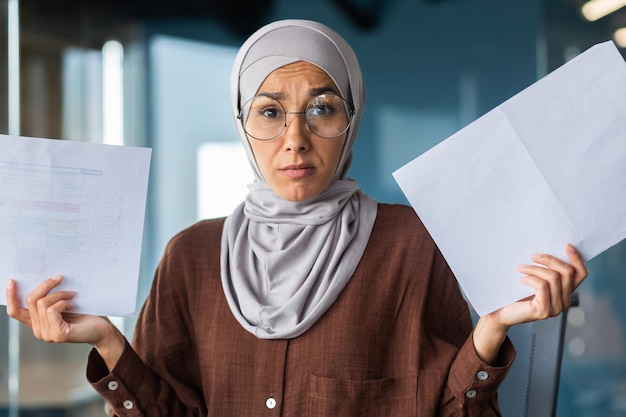 Burned out at work financial problems portrait of a young hijabi muslim woman sitting in the office