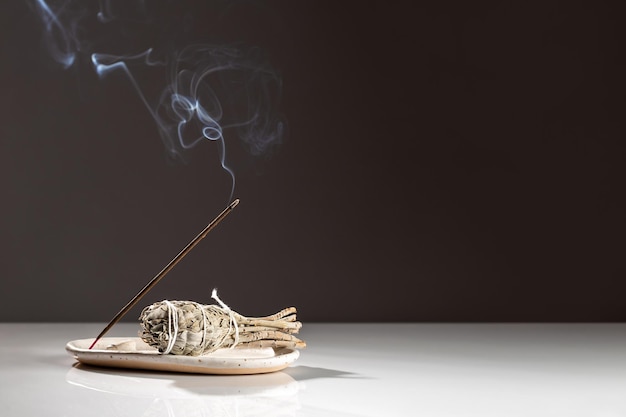 Photo burning aromatic incense smoky stick and sage