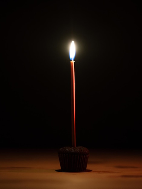 Burning birthday candle on black background