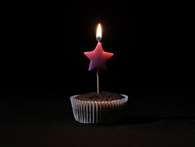 A burning birthday candle on a chocolate cake