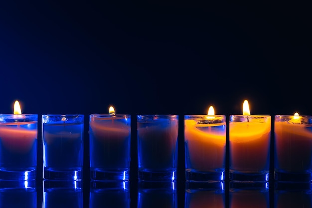 Burning candle on black background with backlight Memorial Day