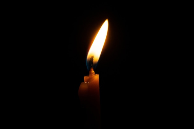 Burning candle on black