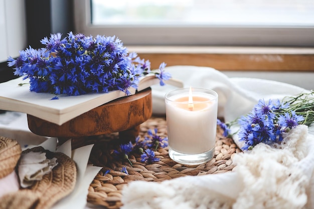 Burning candle book and cornflowers aesthetic summer photo