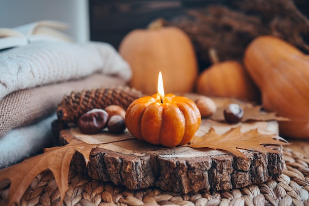 Burning candle in the shape of a pumpkin autumn aesthetic mood